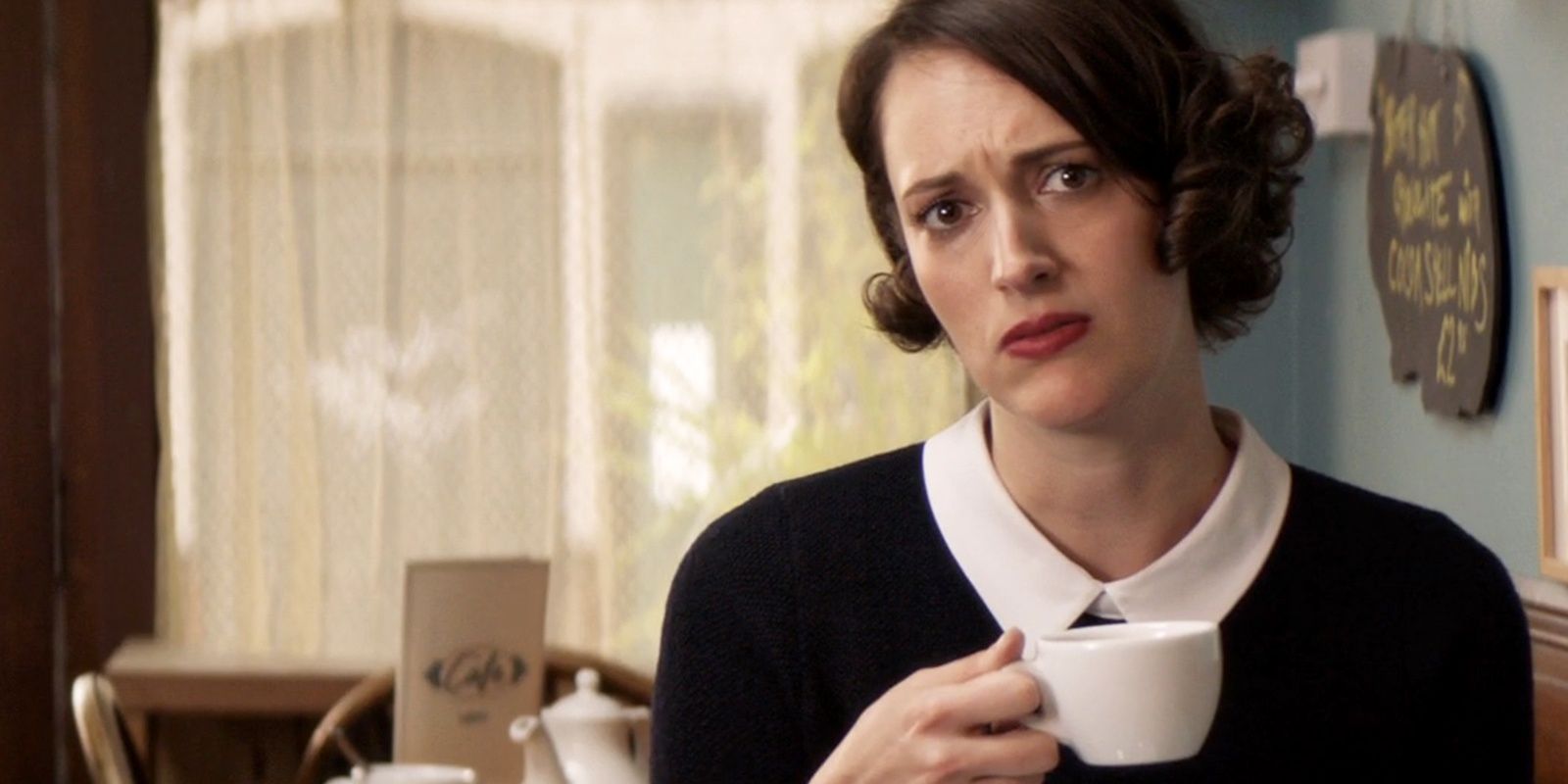 Phoebe Waller-Bridge sitting with cup in hand annoyed expression in amazon prime series Fleabag