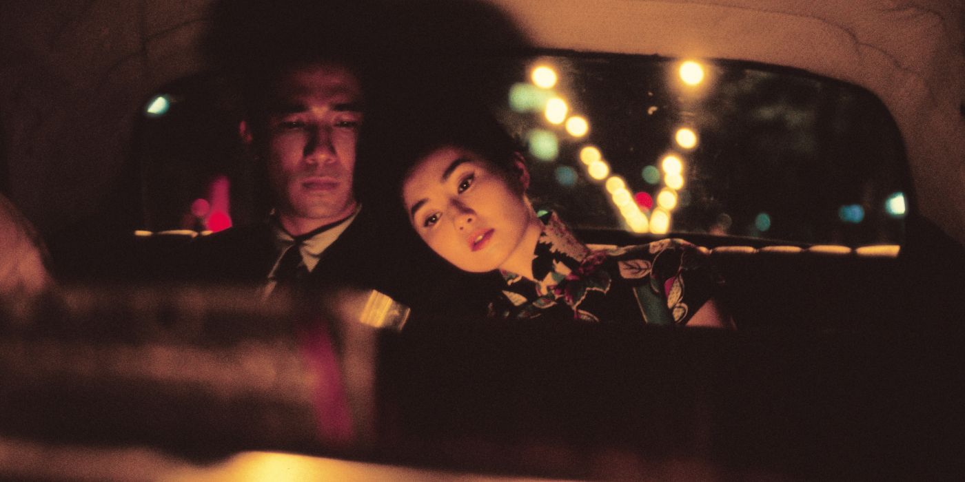 A woman leans on a man behind a cab in In The Mood For Love.