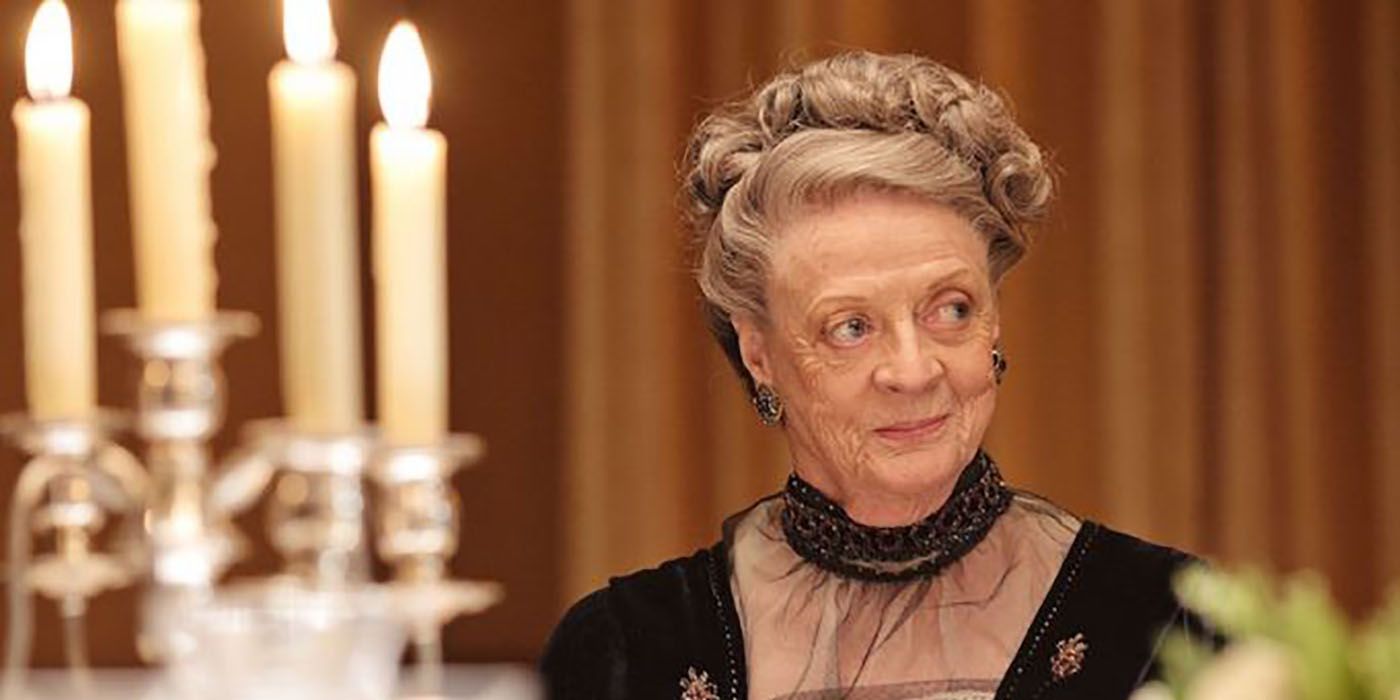 Maggie Smith coyly smiles and looks off to the side in Downton Abbey.