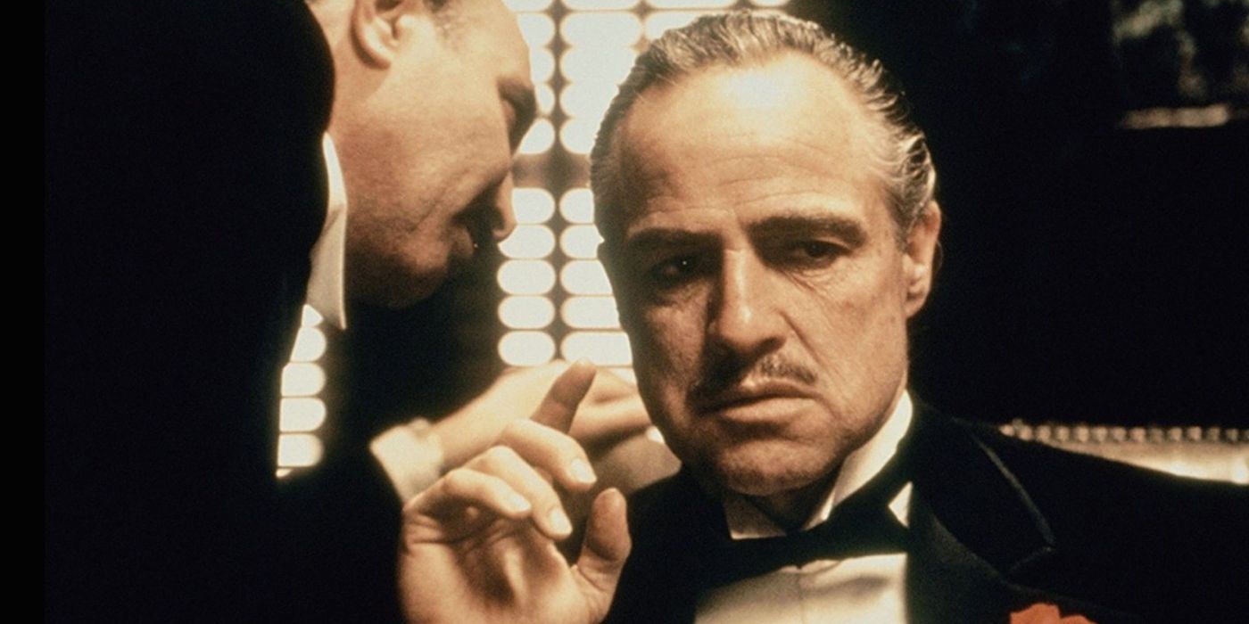 Man whispering into Vito Corleone's ear in The Godfather