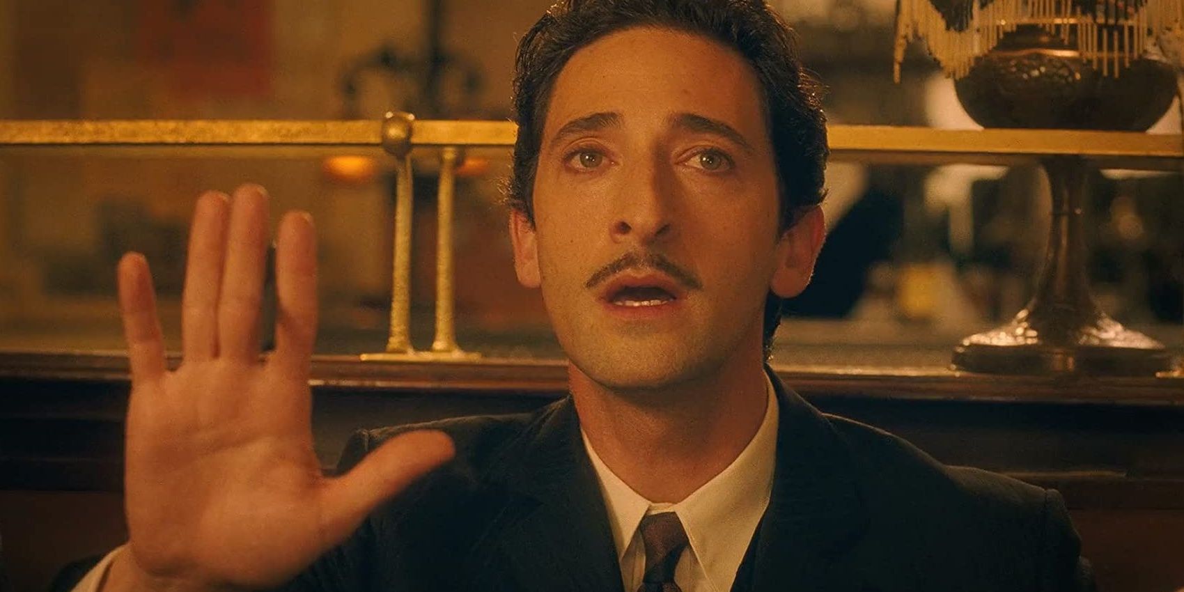 Salvador Dali gestures with hand and gazes off into the distance as he speaks in Midnight in Paris