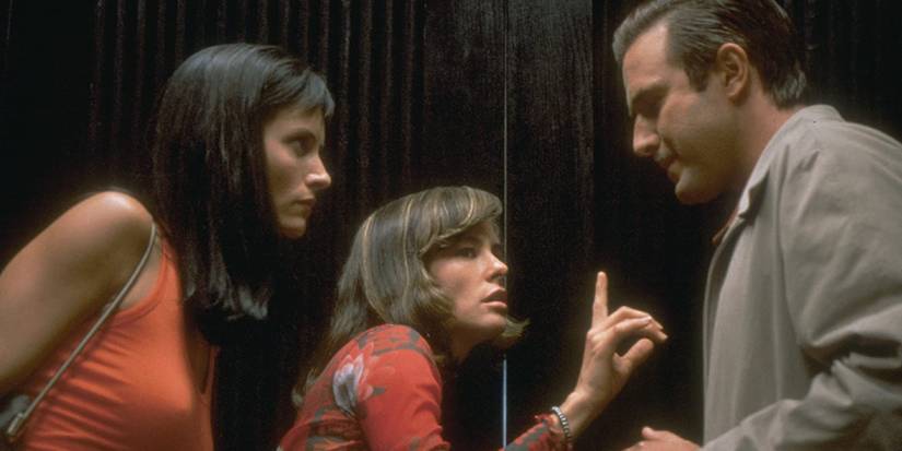 Gale (Courteney Cox), Jennifer (Parker Posey), and Dewey (David Arquette) listening for something in Scream 3.