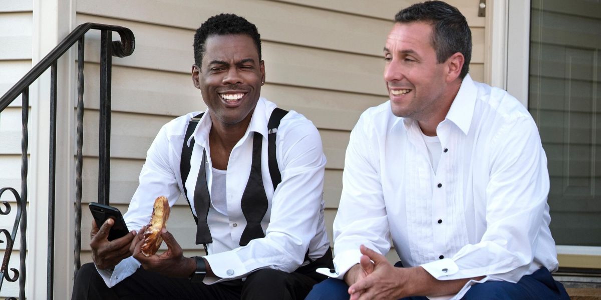Adam Sandler and Chris Rock sitting on a porch and talking in Netflix's The Week Of