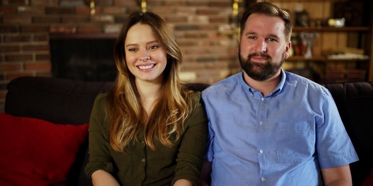 90 Day Fiance's Alan and Kirlyam on set smiling on couch