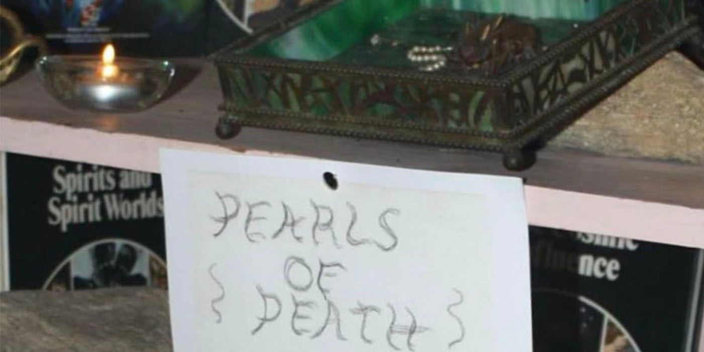 The pearls of death in a container with a paper label tacked to the shelf in the Warren occult museum
