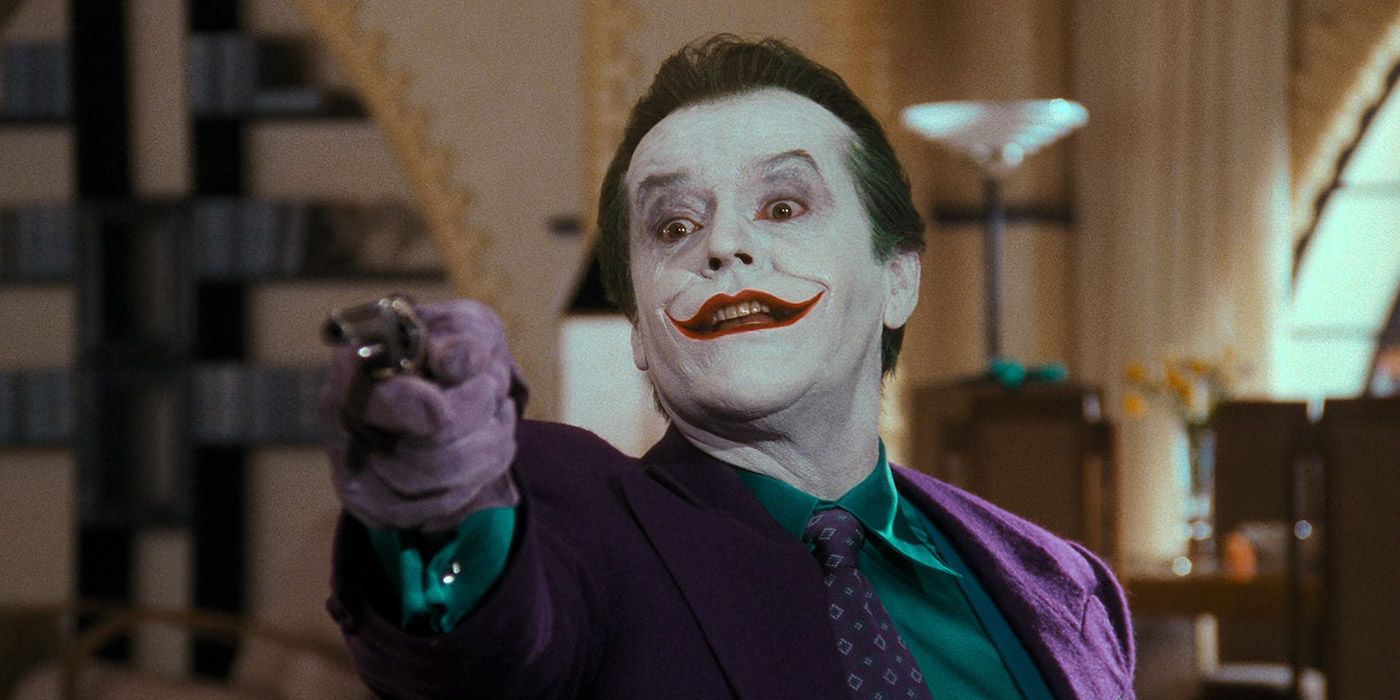 The Joker aims a gun at Bruce Wayne in Batman