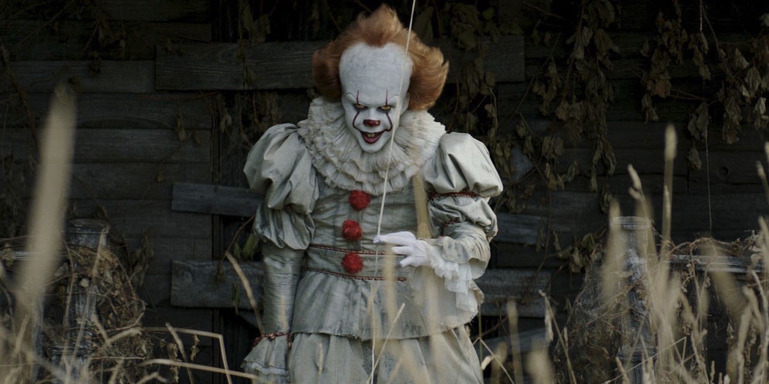 Pennywise the Dancing Clown holding a balloon and smiling in It