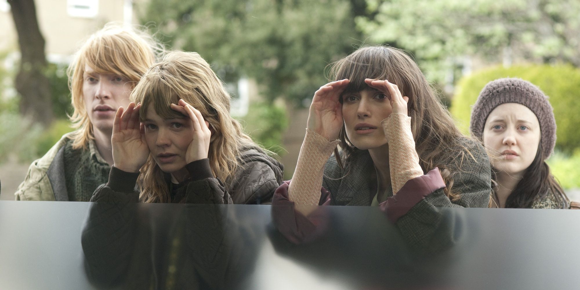 Ruth and Kathy looking through a window in Never Let Me Go