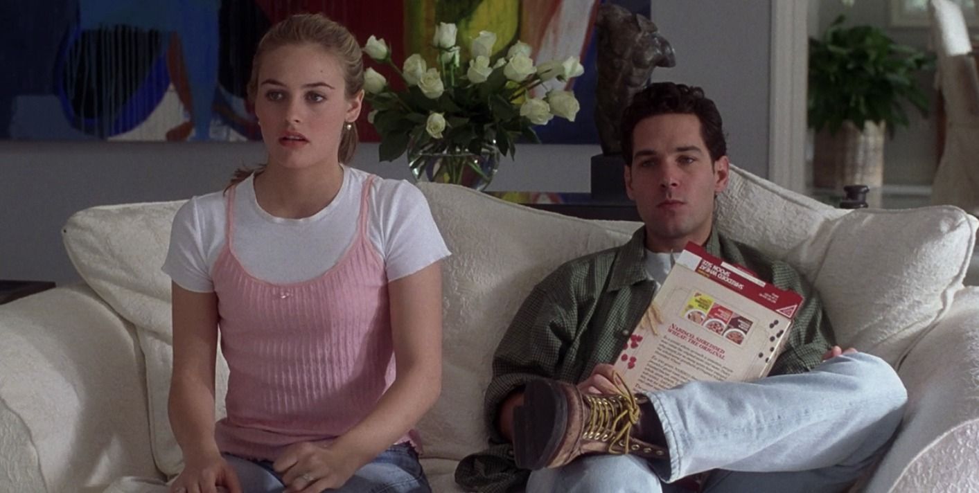 Cher (Alicia Silverstone) and Josh (Paul Rudd) sit next to one another on the couch in Clueless