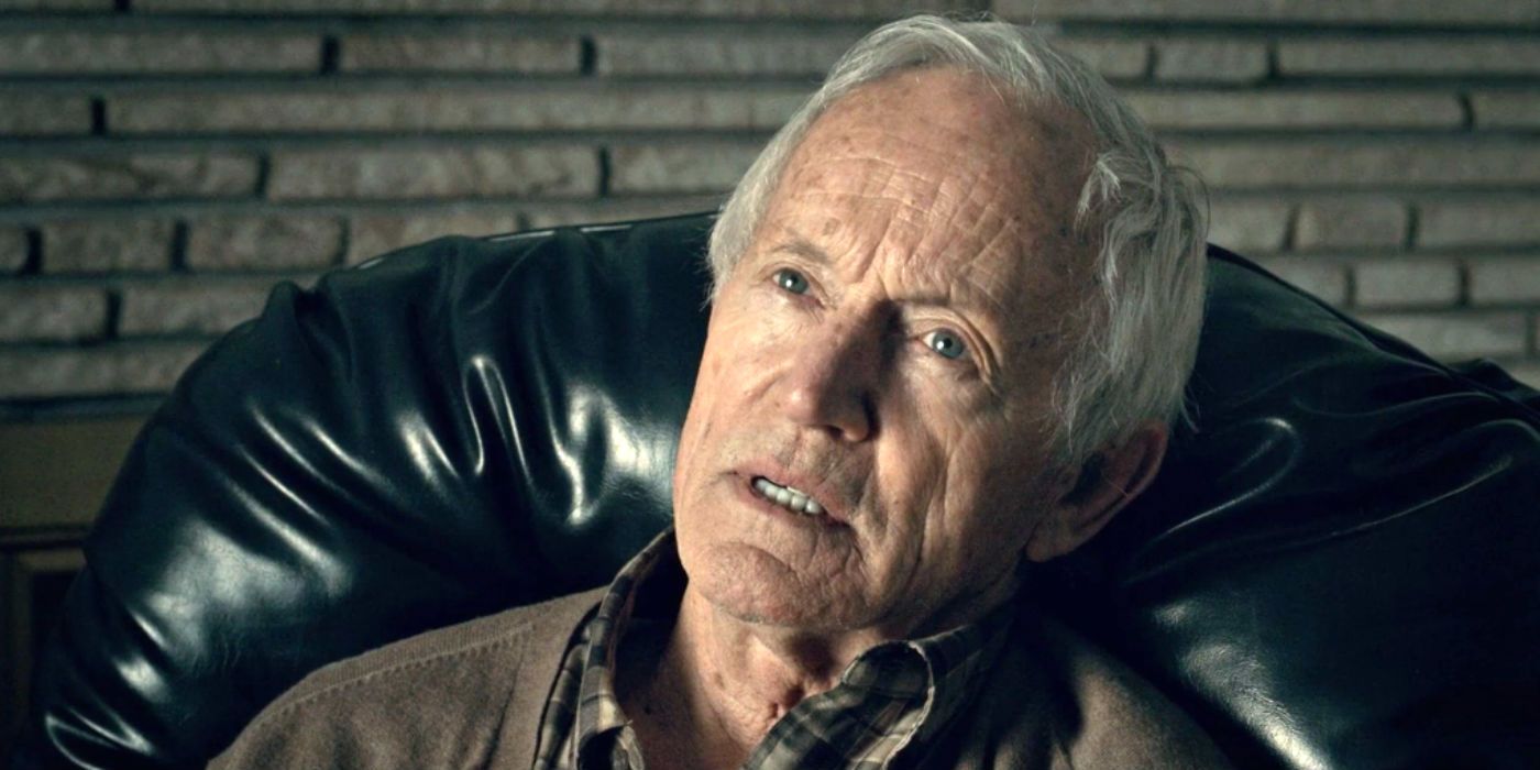Lance Henriksen as Lawrence Wells in Hannibal sits in a chair and looks up.