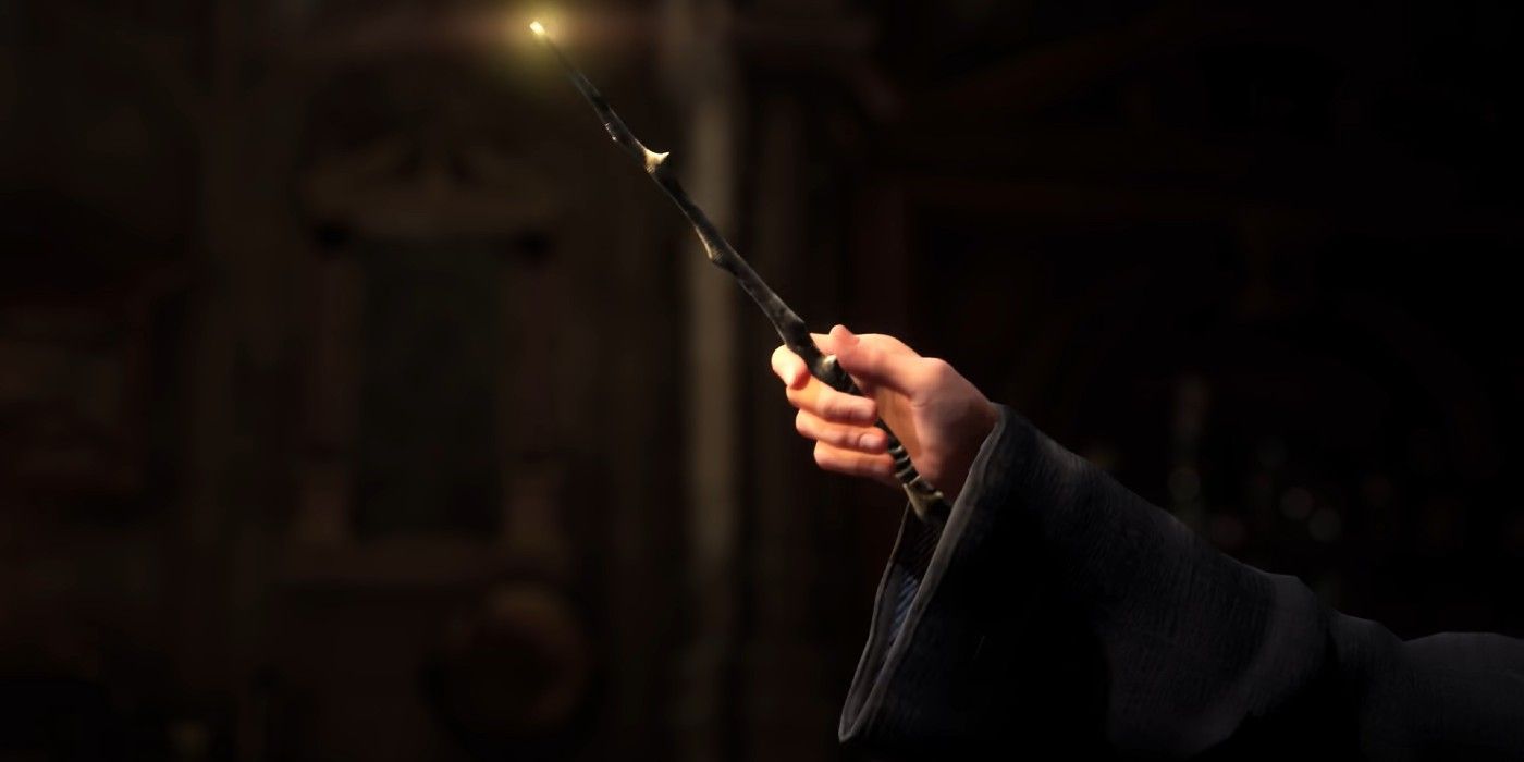 A close-up shot of a player holding a glowing wand in Hogwarts Legacy.