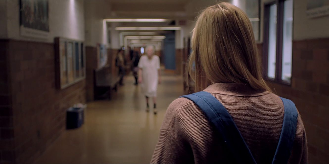 A girl sees an old woman in the hall in It Follows