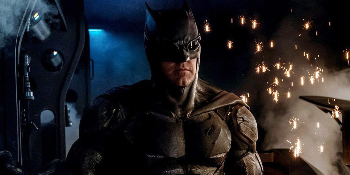 O Batsuit Tático do Batman da Liga da Justiça em frente a faíscas caindo