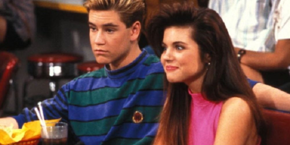 Zack and Kelly sit together in a booth in Saved By The Bell