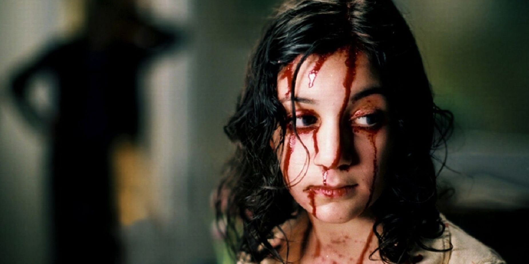 Eli (Lina Leandersson) with blood on her face in Let the Right One In