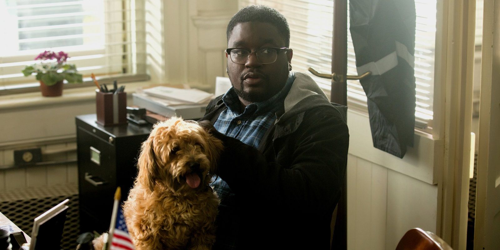 Lil Rel Howery as Rod holding his dog in Get Out.