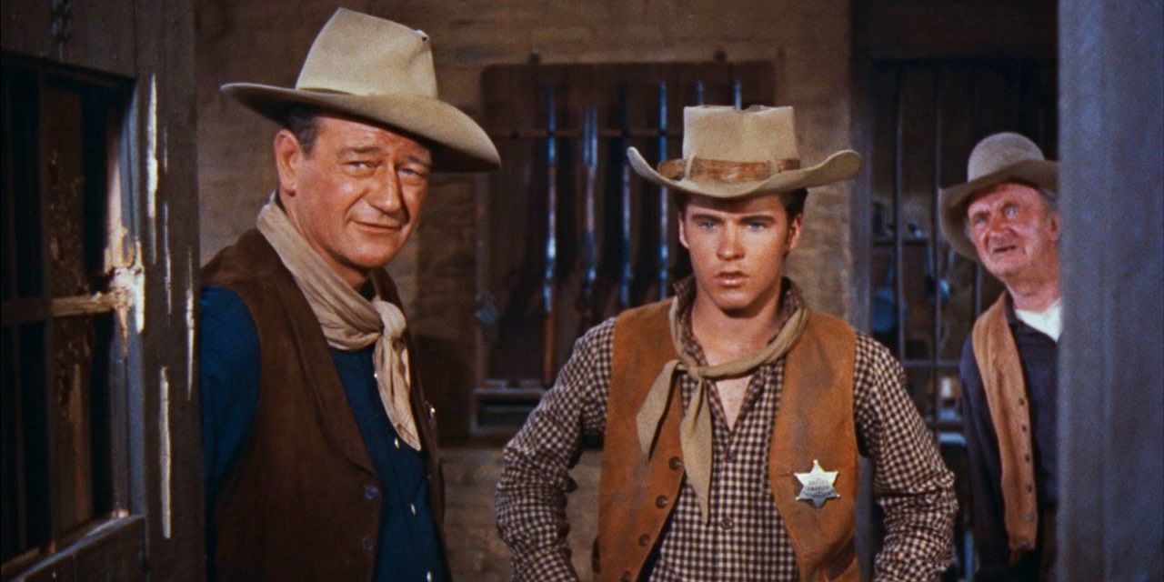 John Wayne stands with two other men in Rio Bravo.