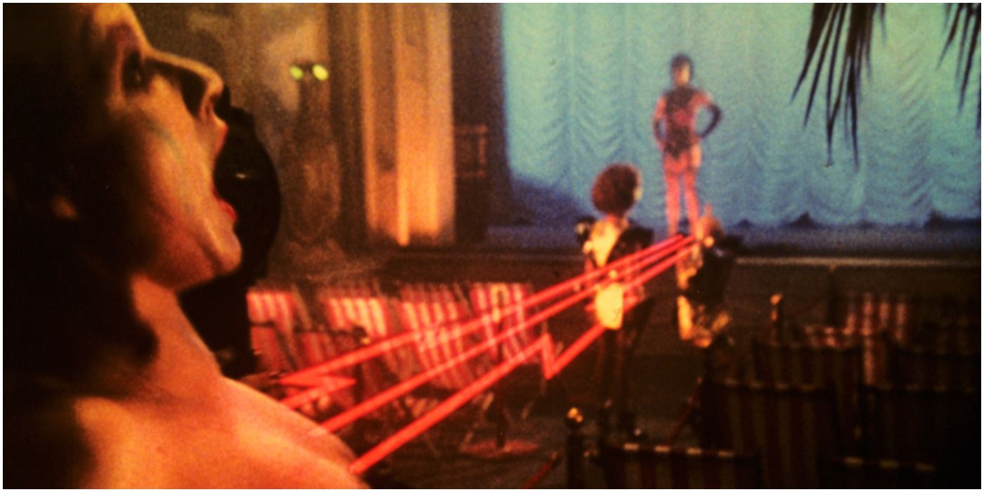 Rocky Horror Picture Show's Columbia singing in front a stage with a leaser beam pointed at her