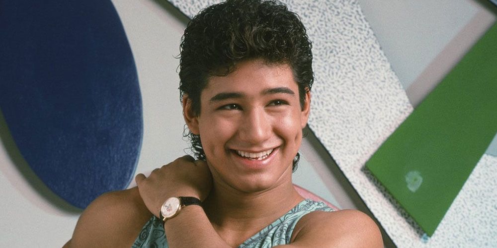 Slater smiles in front of geometric shapes on the wall at The Max in Saved By The Bell