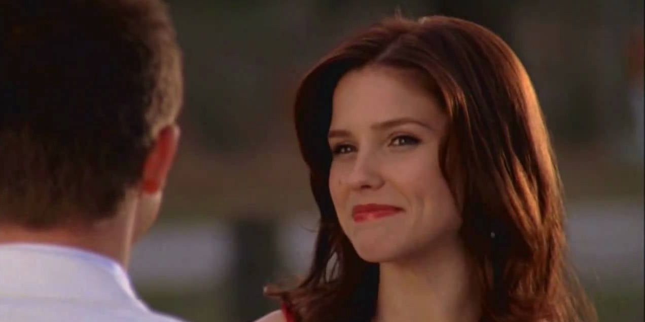 Brooke Davis sorri para Mouth McFadden na quadra de basquete Rivercourt enquanto usava um vestido de baile vermelho