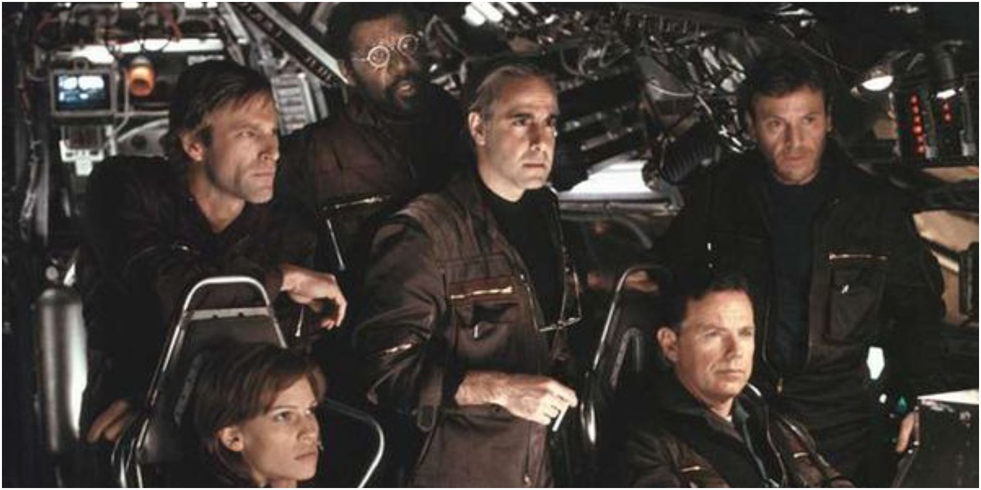 The scientists stand in the cockpit of the ship in The Core