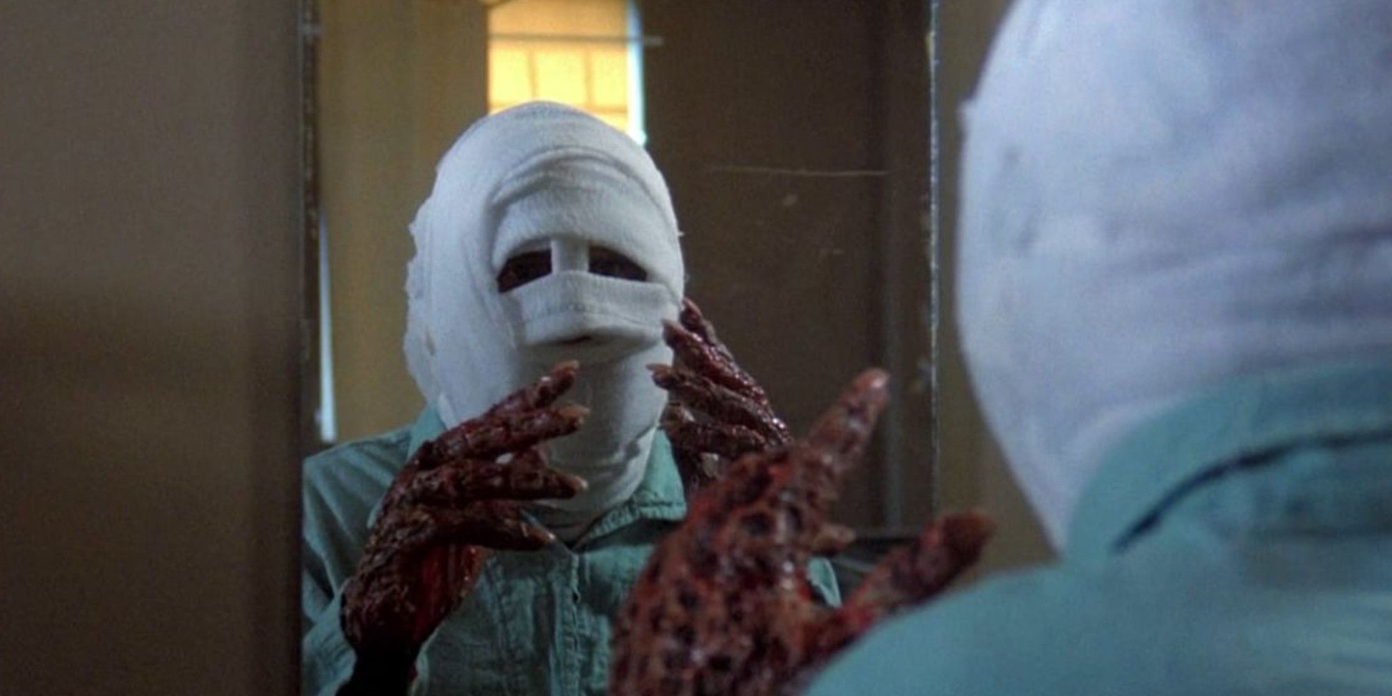 A man with a bandaged face stares at himself in the mirror, a still from The Incredible Melting Man