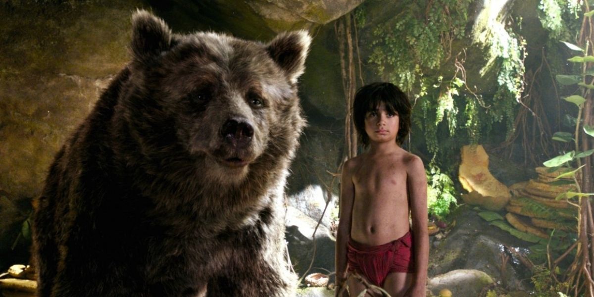 Neel Sethi as Mowgli next to CGI Baloo in The Jungle Book (2016)