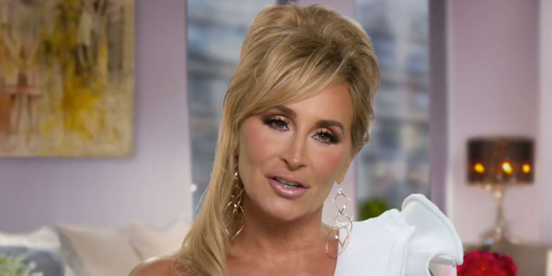 Sonja Morgan talking to the camera with her hair up and wearing a white dress on RHONY