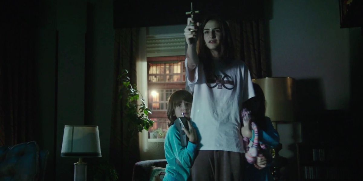 Sandra Escacena in Veronica holding up a crucifix as kids hide behind them