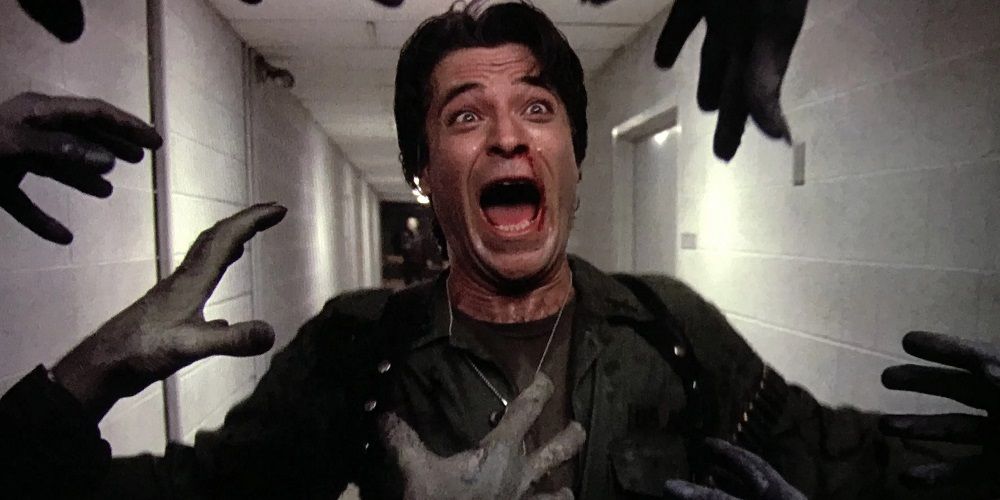 Joe Pilato screams as zombie arms reach out to him in Day of the Dead