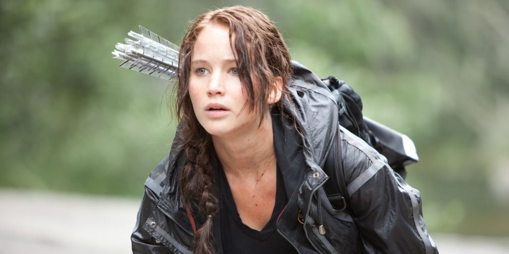 Katniss Everdeen runs through the woods in The Hunger Games
