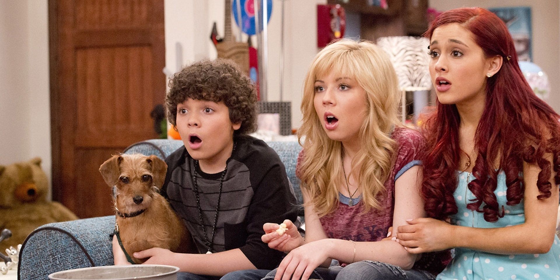 Deuce, Sam, and Cat on the couch with a dog and a bowl of popcorn appearing shocked in Sam and Cat