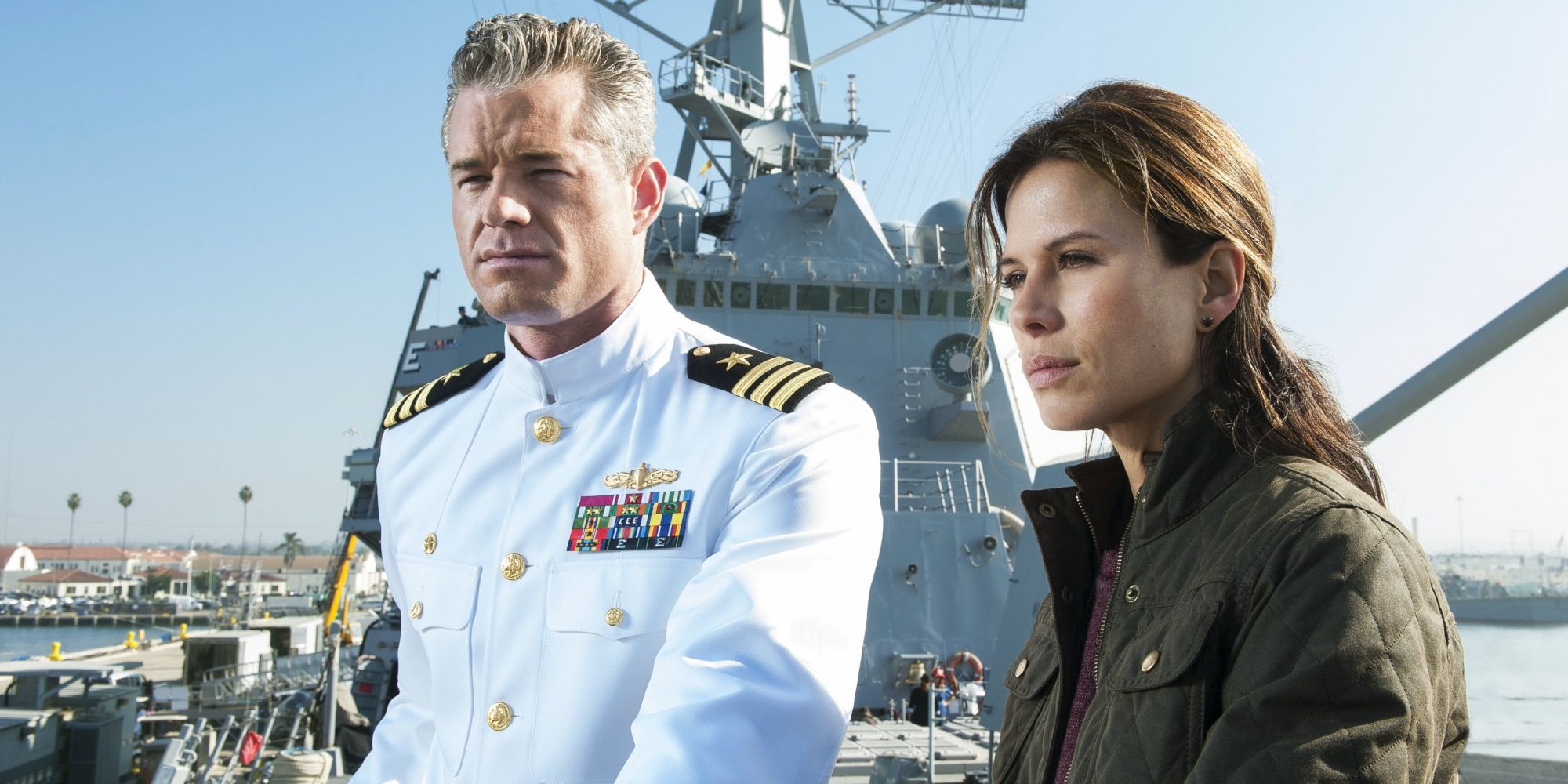 A man in a Navy uniform stands next to a woman in The Last Ship.