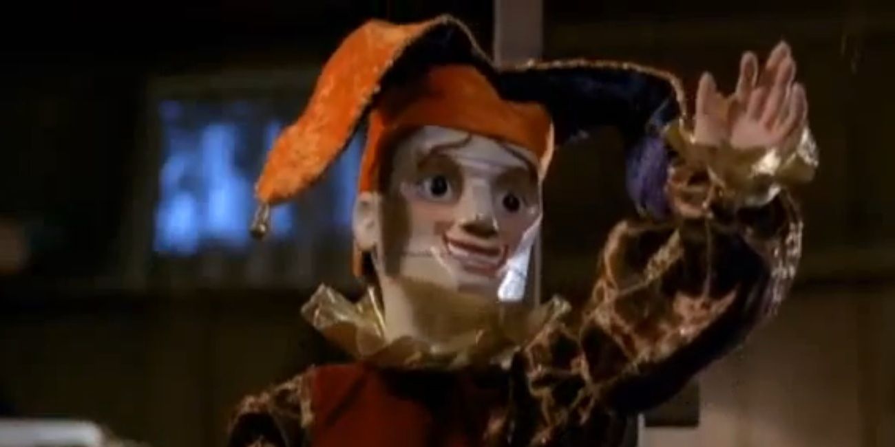 A jester waves at the viewer