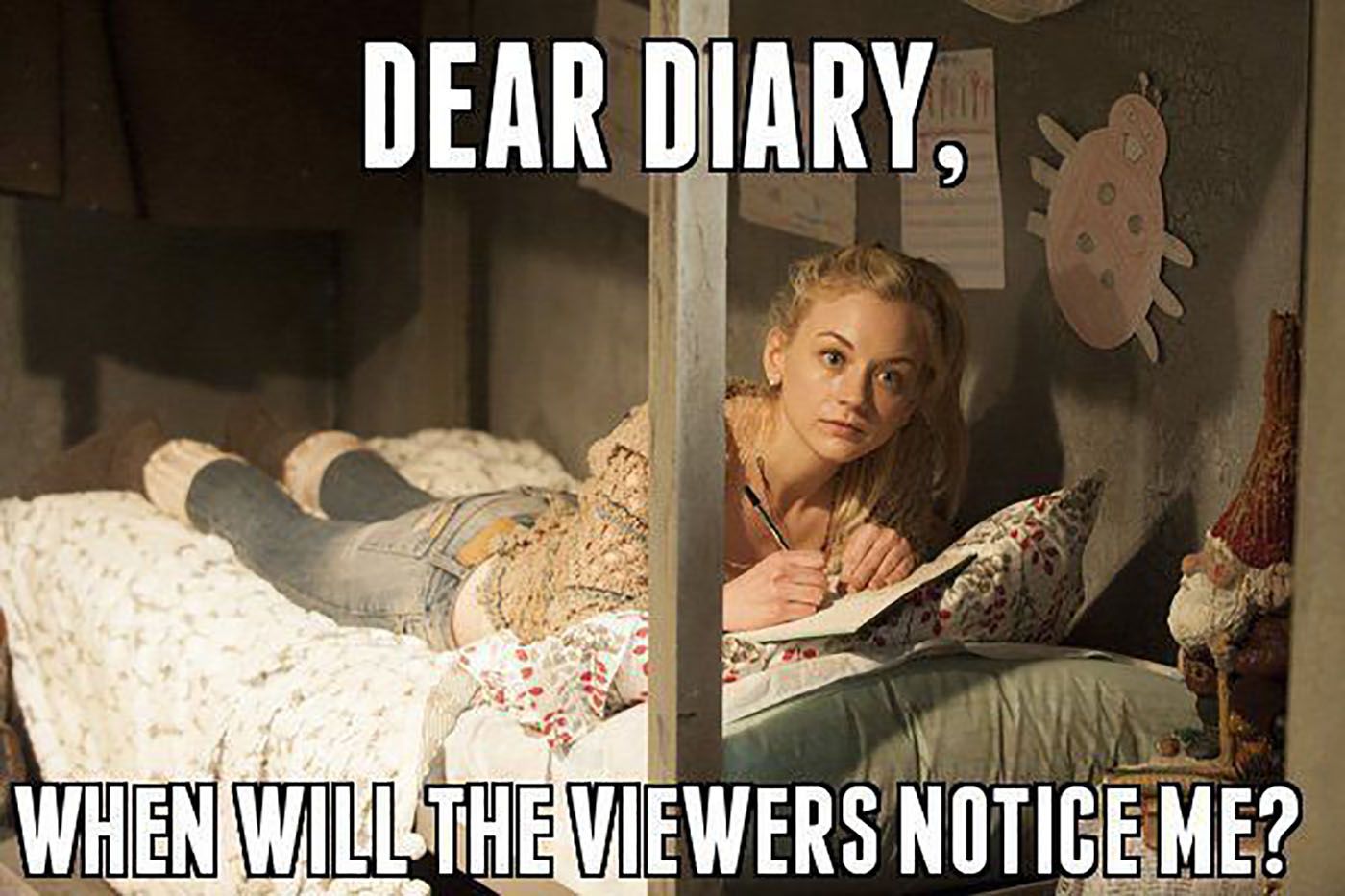 Beth lying on a bed with a notebook in a scene from The Walking Dead.