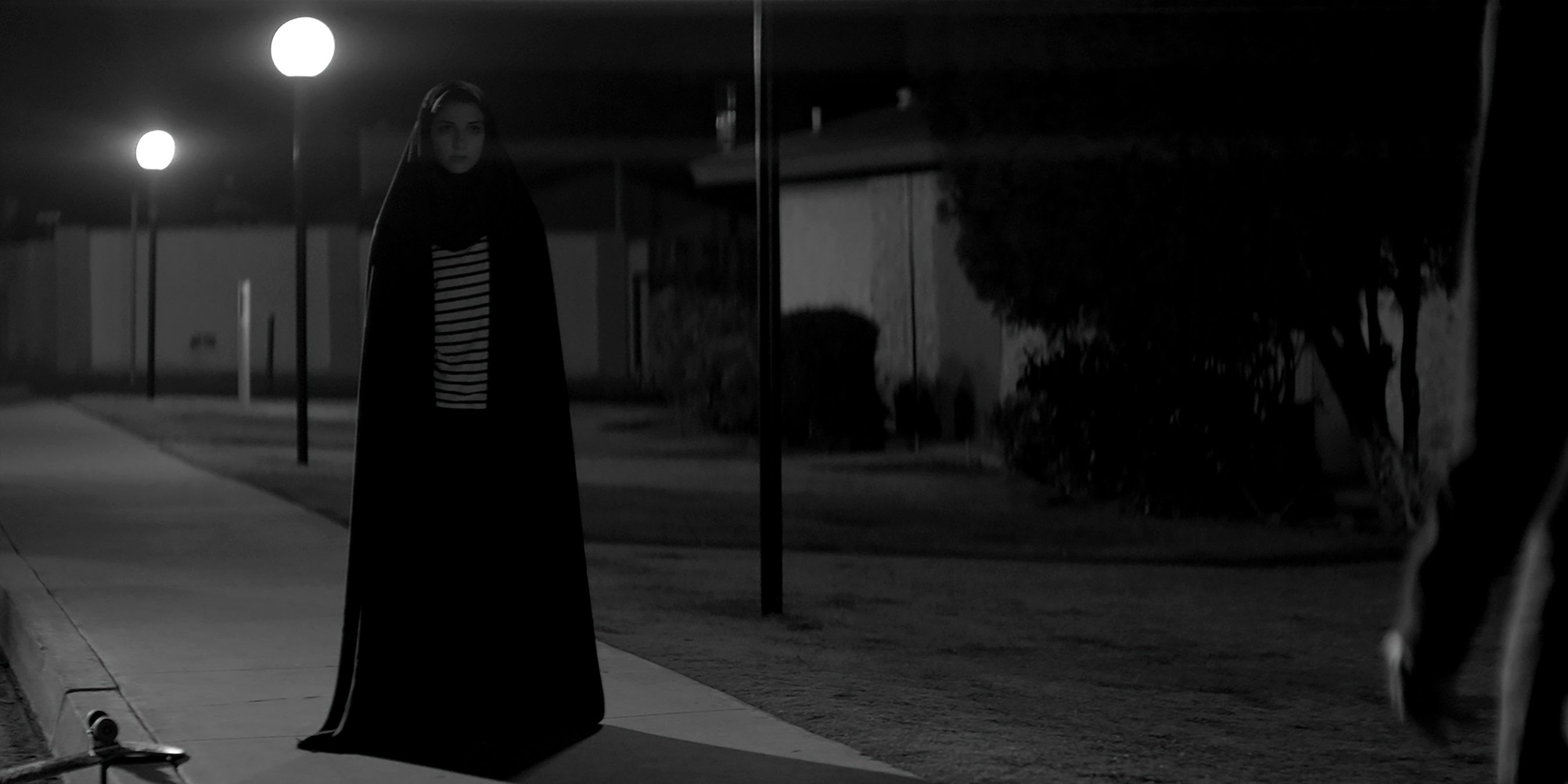 The Girl standing on the street in A Girl Walks Home Alone at Night