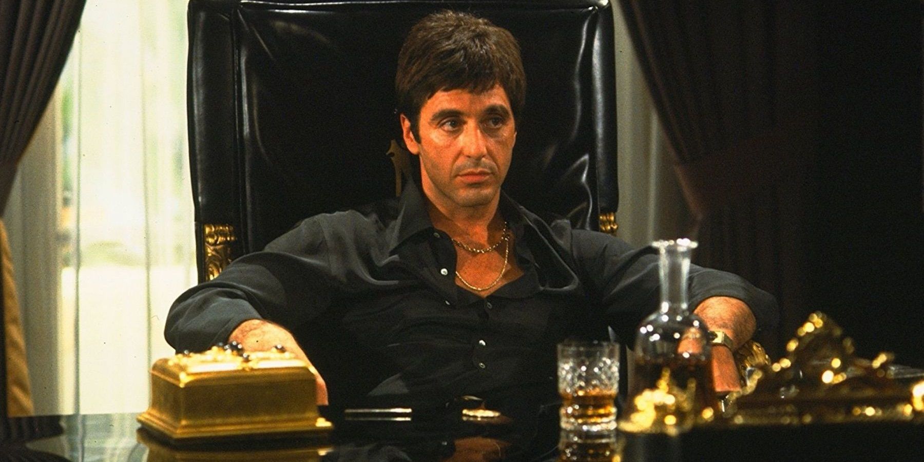 Al Pacino as Tony Montana sitting behind his desk in Scarface