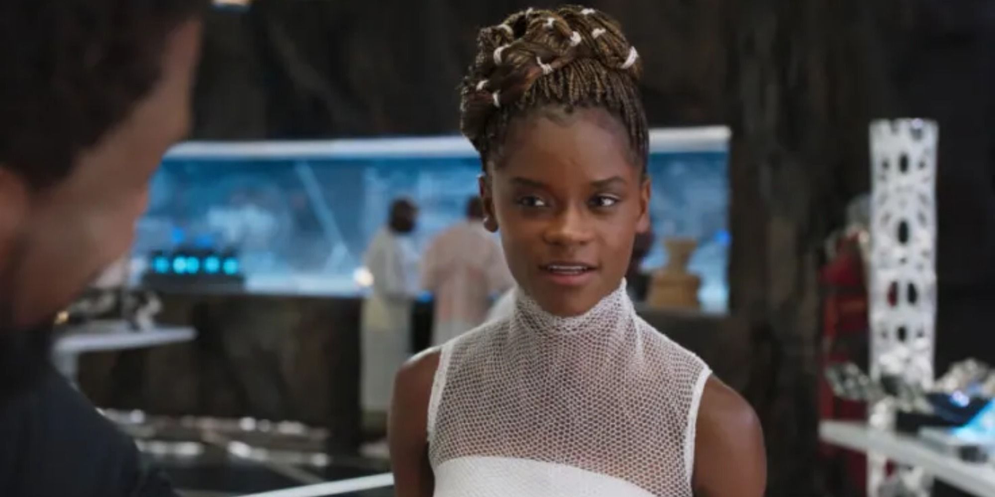 A screenshot of Letitia Wright's Shuri showing her brother T'Challa about his upgrades in Black Panther