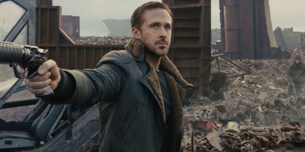 Ryan Gosling fires his gun in a junkyard in Blade Runner 2049