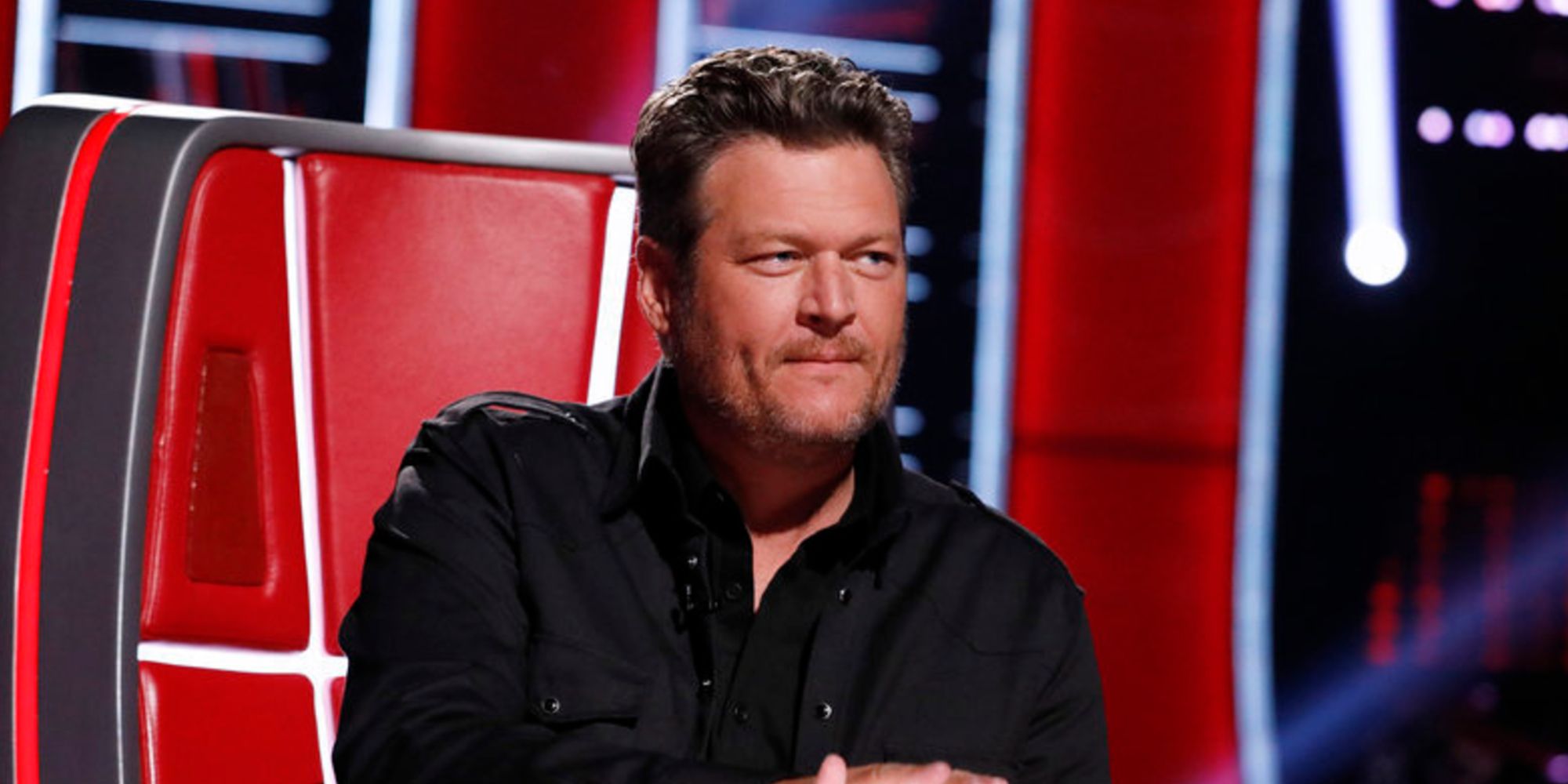 Blake Shelton sitting in a red chair on The Voice