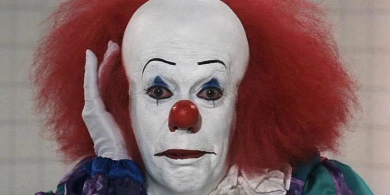 Pennywise resting his head on his hand and looking unassuming in IT