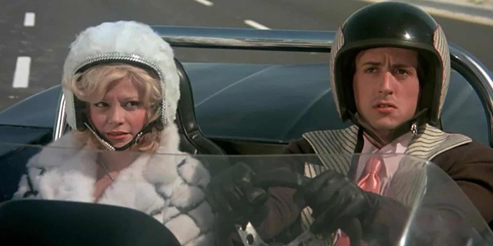 A couple inside a race car in Death Race 2000.