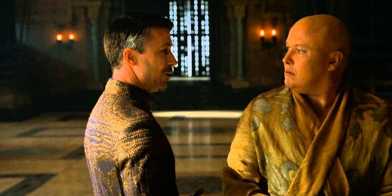 Mindinho e Varys conversando na sala do trono em Game of Thrones.