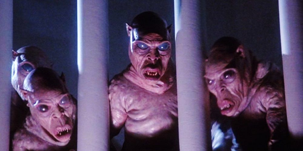 Three demons looking through a gate in The-Gate-1987