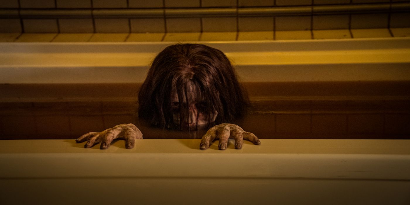 A woman crawls out of a bath in The Grudge