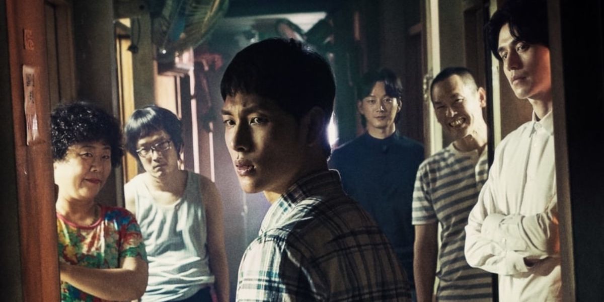 Jong-Woo with building tenants behind him in Hell is Other People