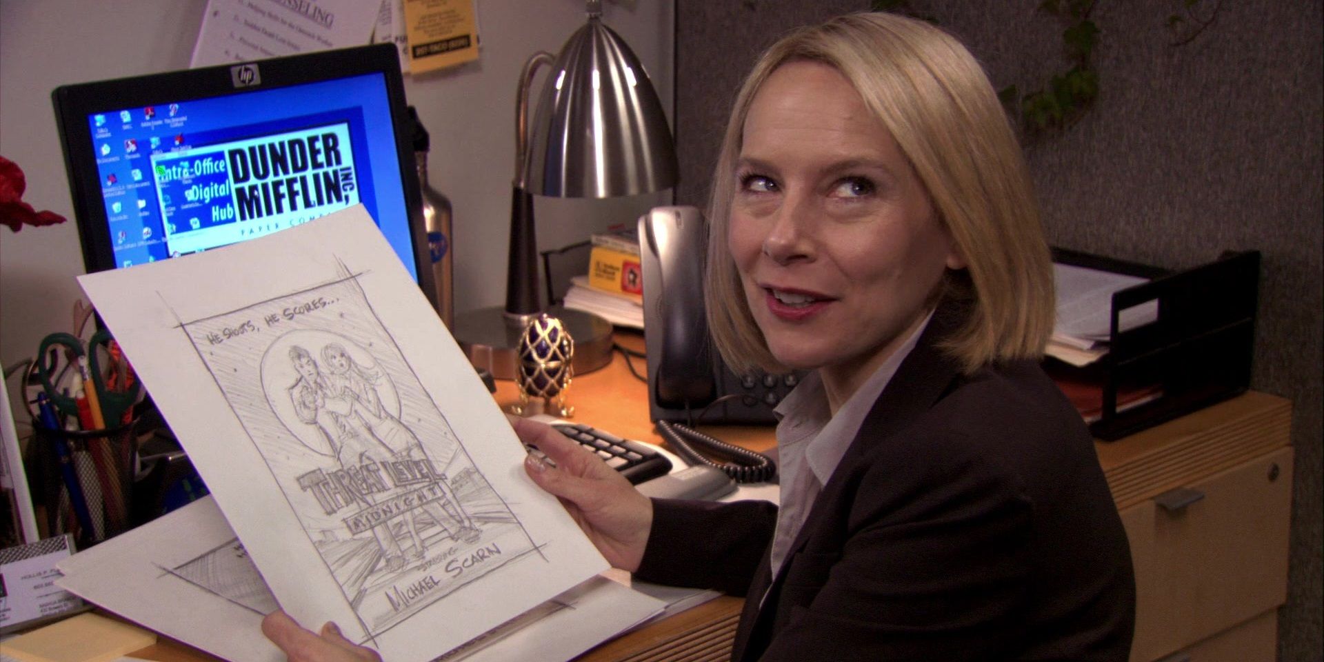 Holly Flax in The Office sitting at her desk.