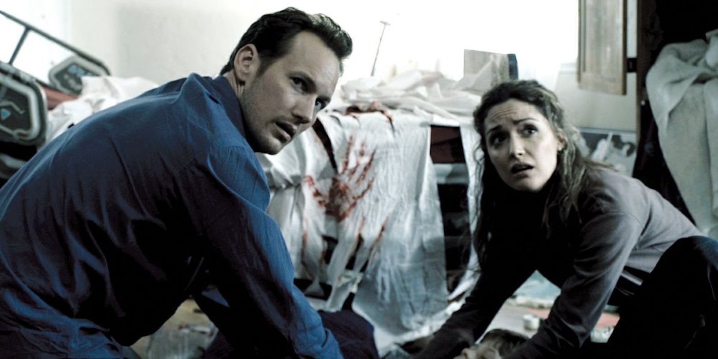 Patrick Wilson and Rose Byrne in front of a bloody handprint in Insidious