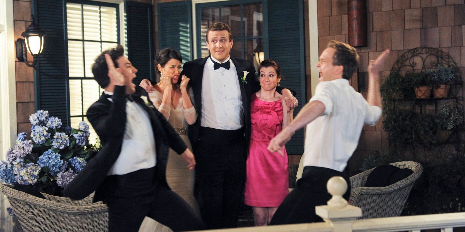 Ted and Barney about to high five in front of Robin, Marshall, and Lily on the balcony in How I Met Your Mother