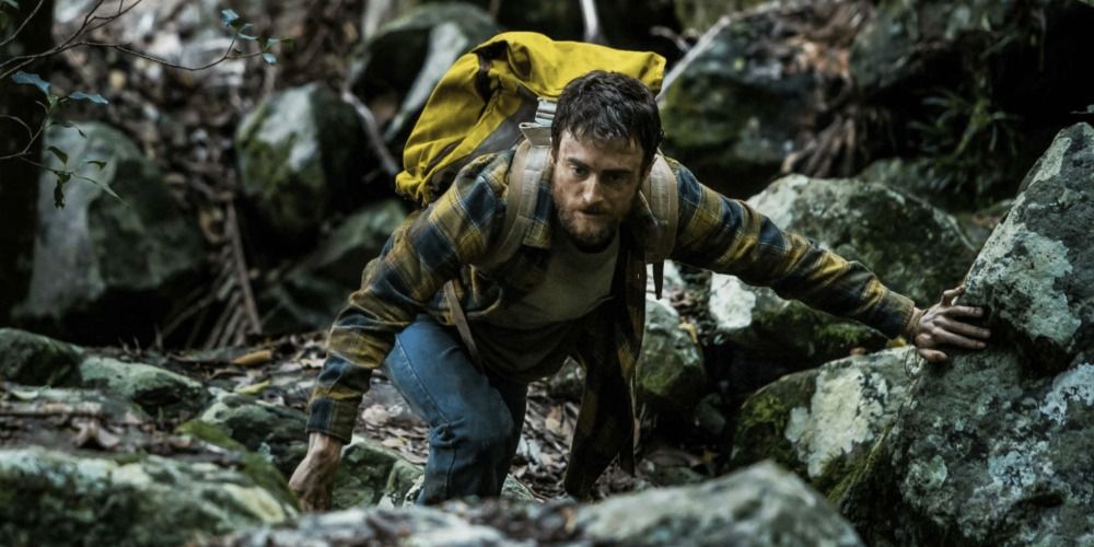 Daniel Radcliffe climbing a boulder in Jungle